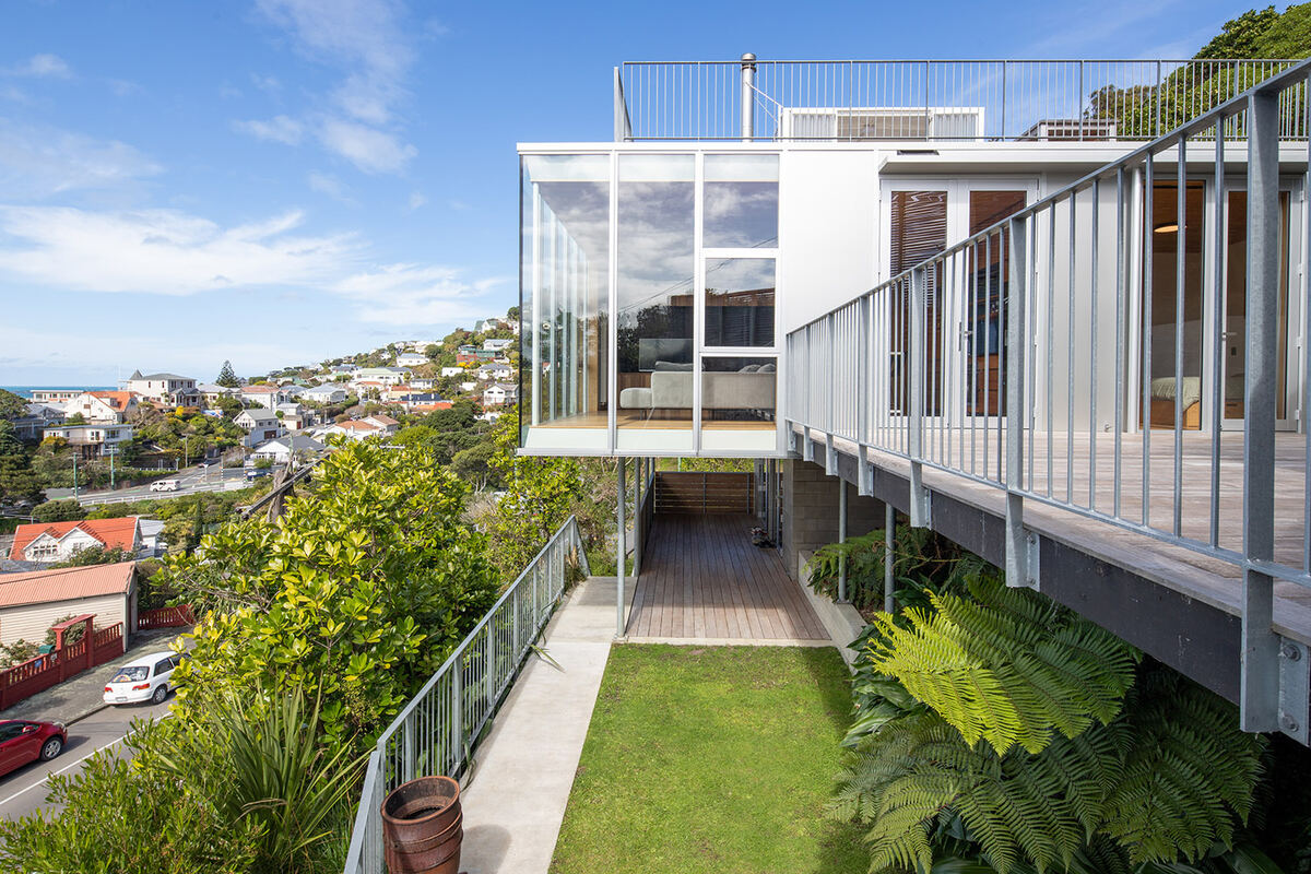 Modern hillside home with glass corner living room and deck