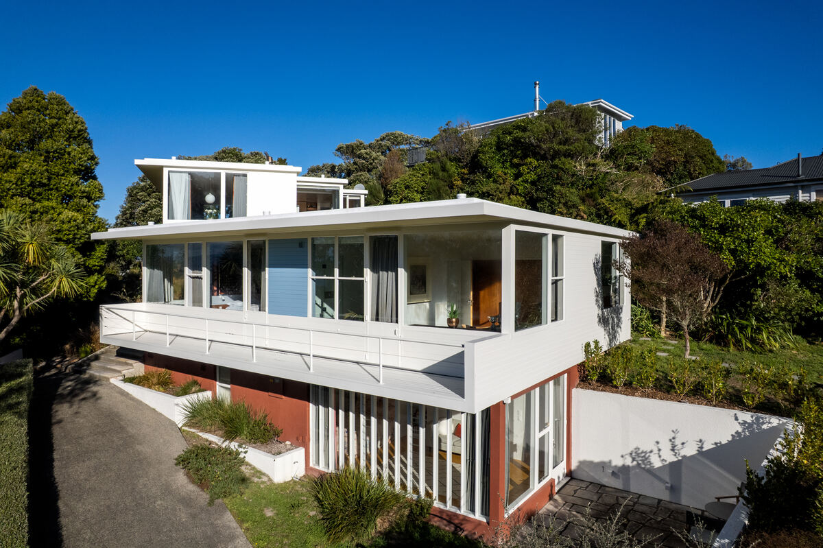 Aerial view of a modernist home on a bush-clad hillside