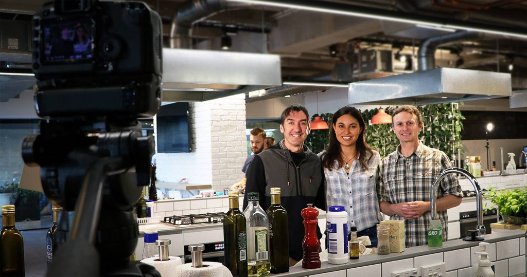 Andy McGrath filming three presenters in a commercial kitchen