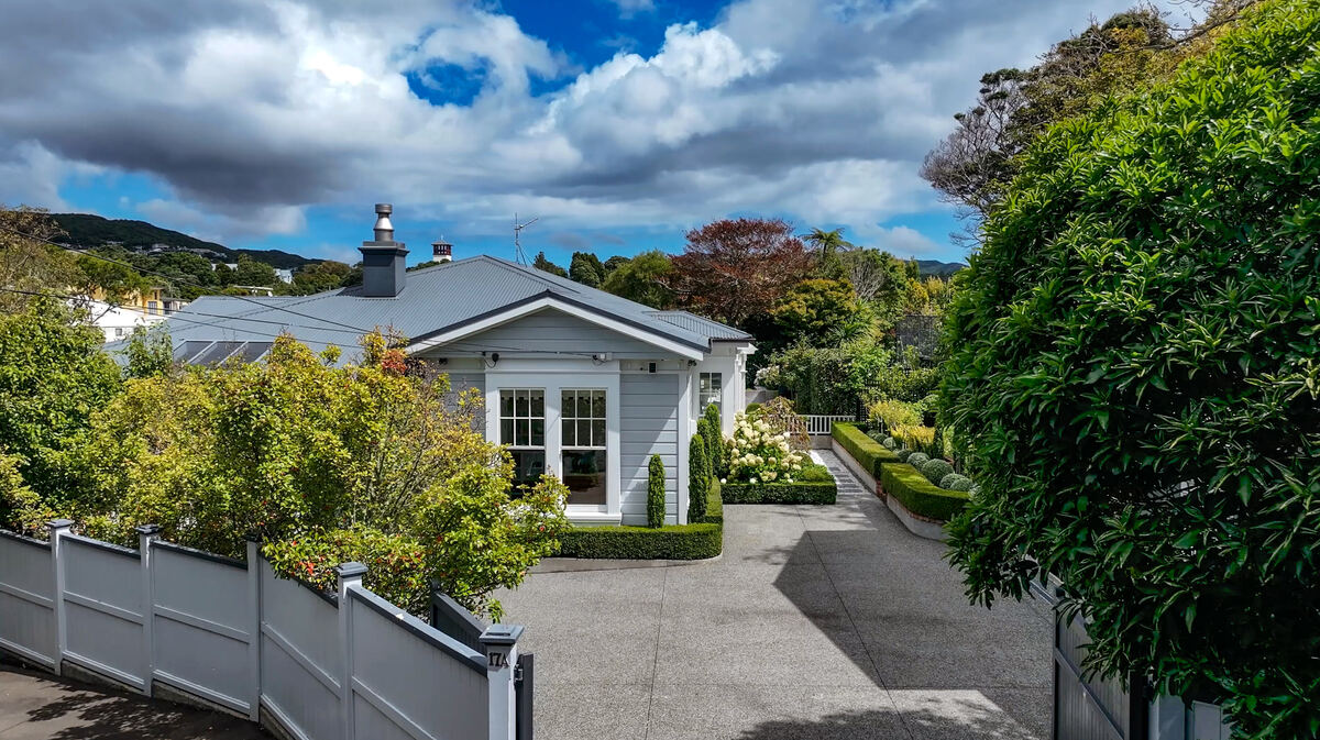 Villa entrance with clipped hedges and stone driveway